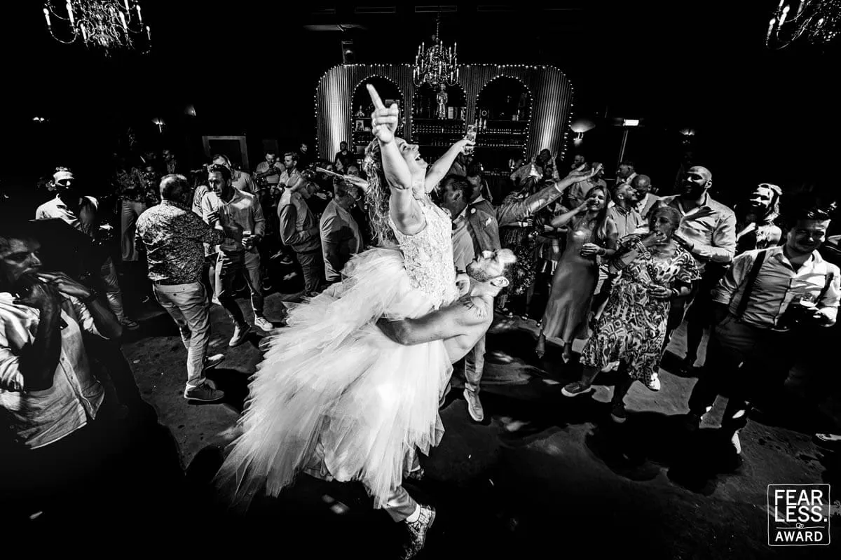 De bruid wordt boven de dansende gasten uit getild, bekroond met een Fearless Award (zwart-wit)