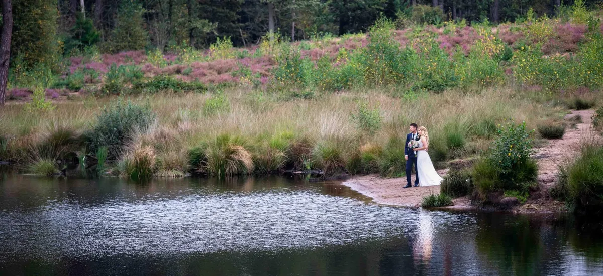 Een bruidspaar aan de rand van een ven op de heide