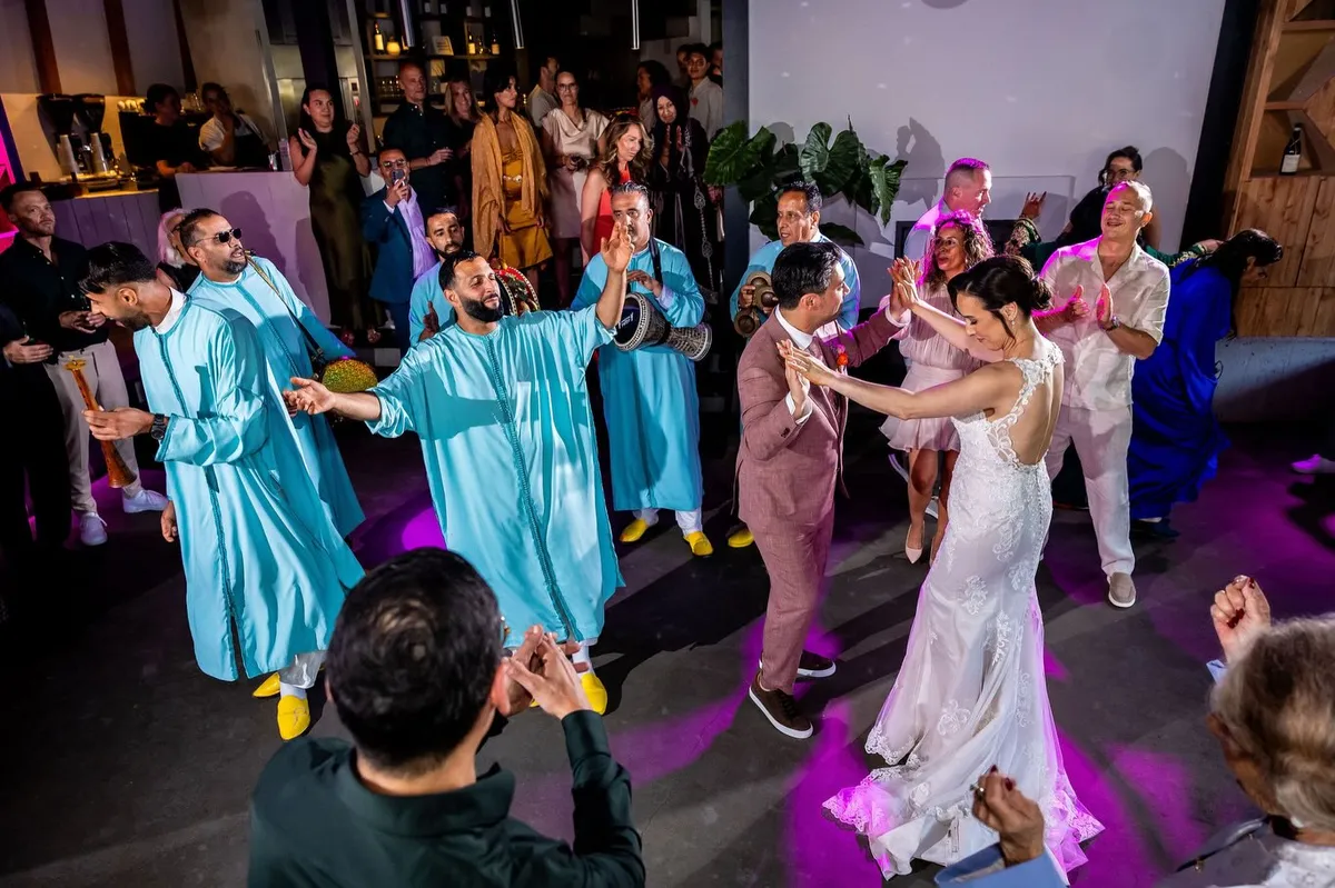 De Marokkaanse band Dakka Manar speelt en danst rond het bruidspaar op de dansvloer