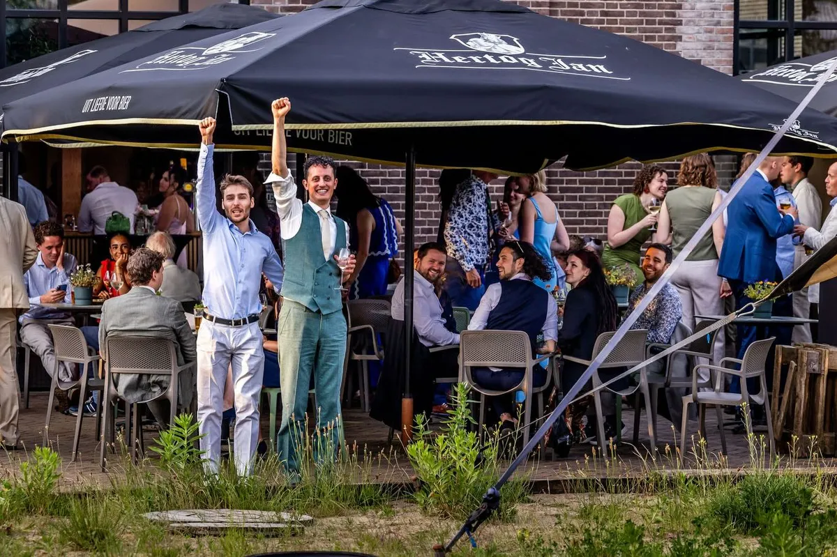 Florence en Jan juichen op het terras van Ketelhuis aan de Werf, tussen hun gasten