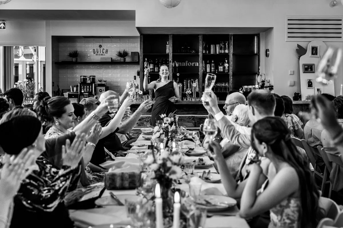 Gasten proosten tijdens het diner (zwart-wit)