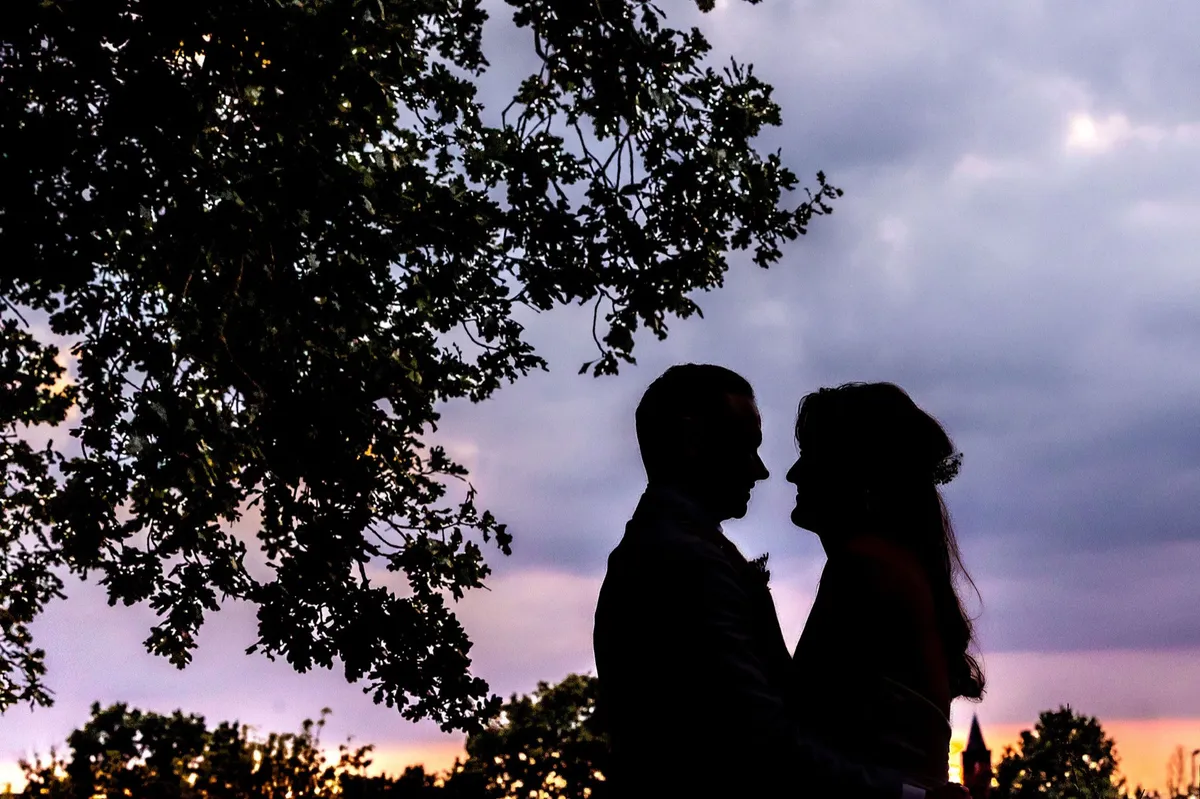 Silhouet van het bruidspaar bij zonsondergang in Bussum