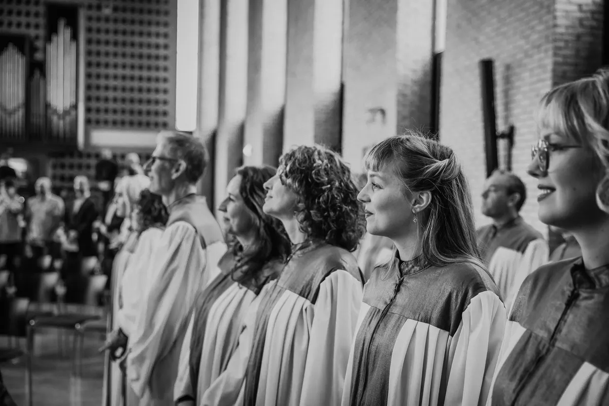 Een koor zingt tijdens de trouwceremonie (zwart-wit)