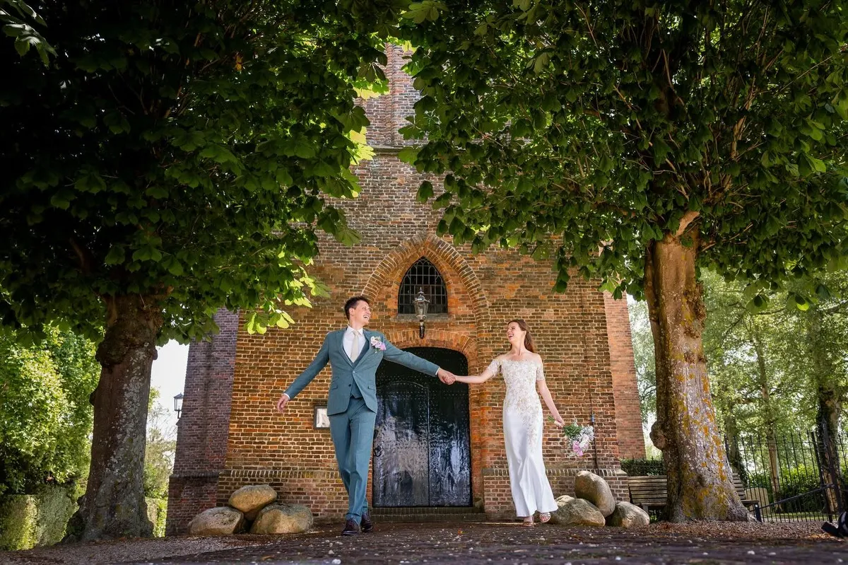 Florence en Jan lopen hand in hand weg bij het oude kerkje van Kortenhoef